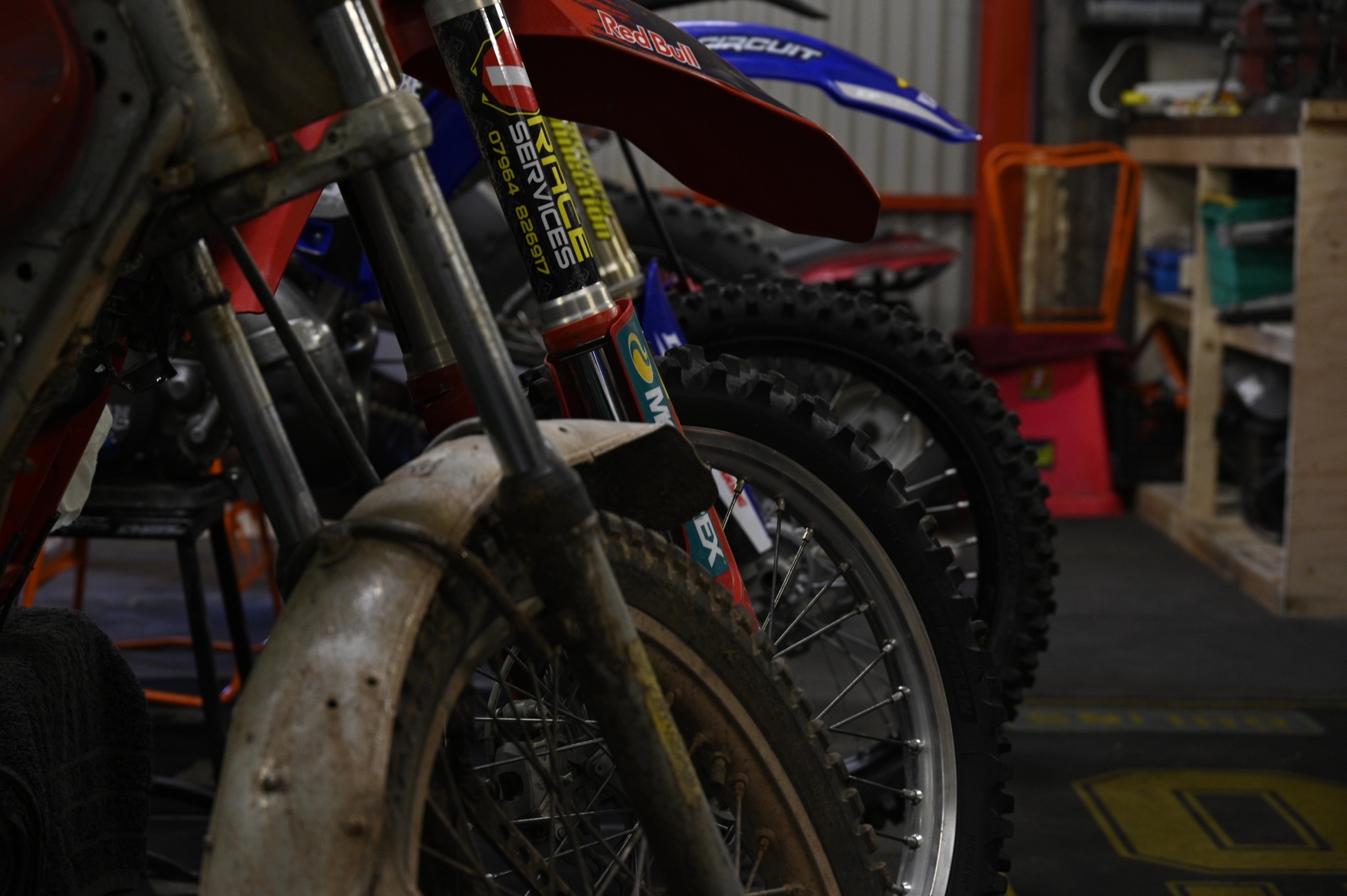 Motocross bikes lined up in the Race Services workshop